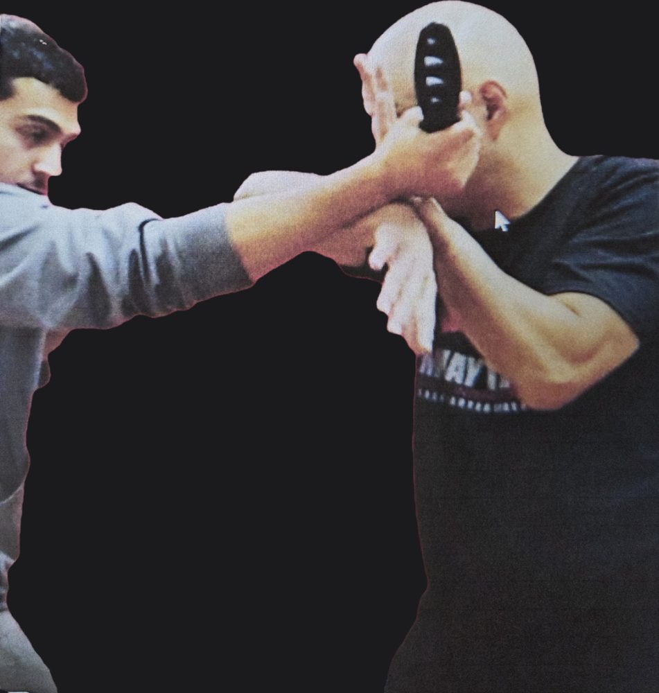 Serrada Escrima practitioner checking a training knife at close range during a knife defense demonstration
