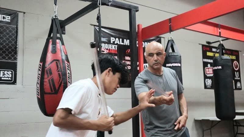Master Edward Garcia coaching a student on stick angles during a private lesson