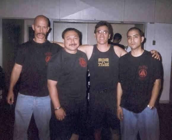 Vintage photo of four Serrada Escrima practitioners in matching black Cabales Serrada shirts