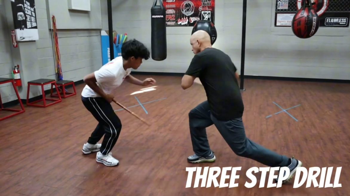 Master Edward lunging forward as a student defends during the three-step drill