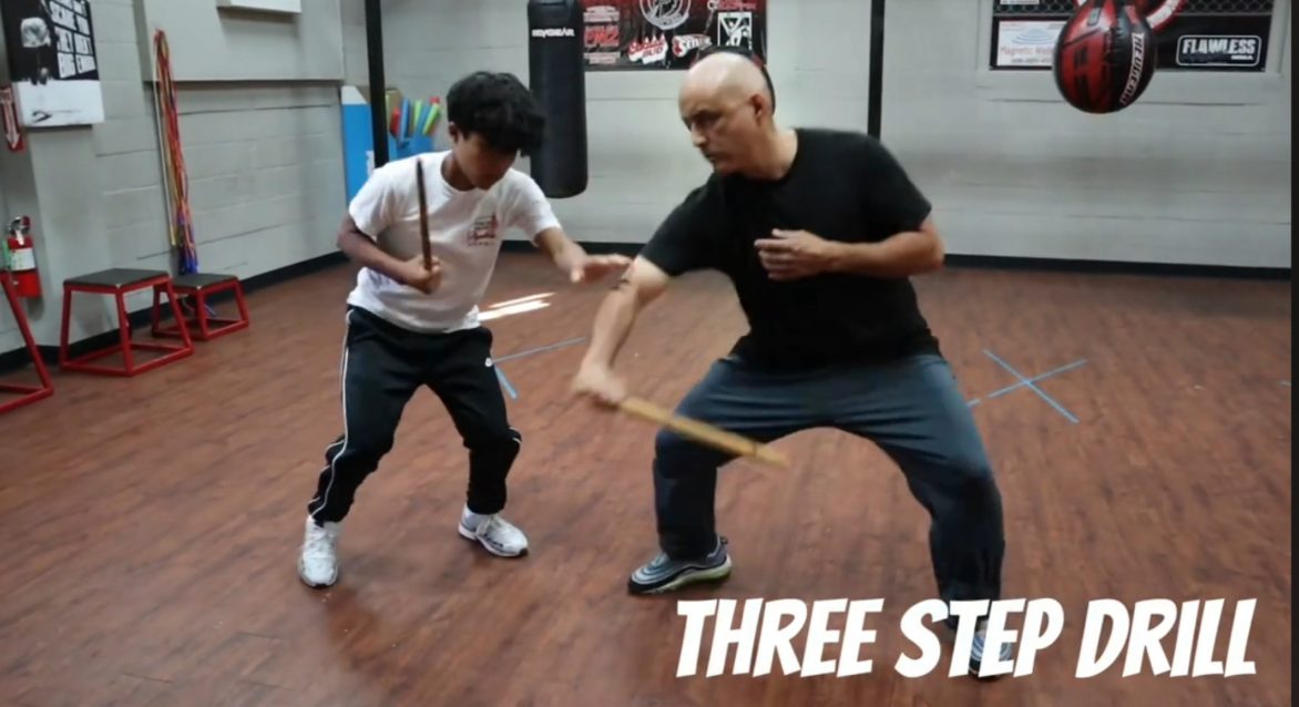 Master Edward Garcia and a teen student practicing the Serrada Escrima three-step drill with training sticks